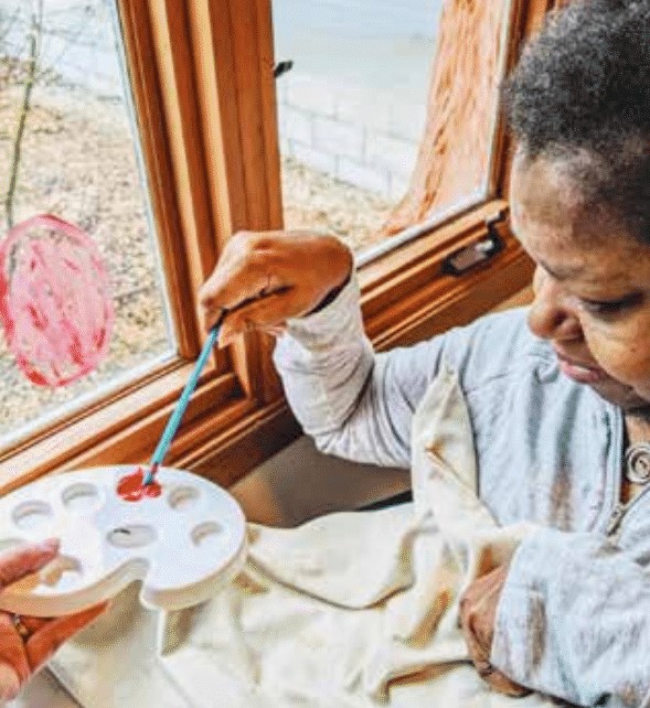 Mary sitting near a window, painting