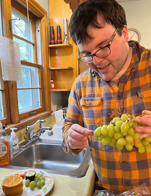 Al is in his kitchen, holding a bunch of grapes